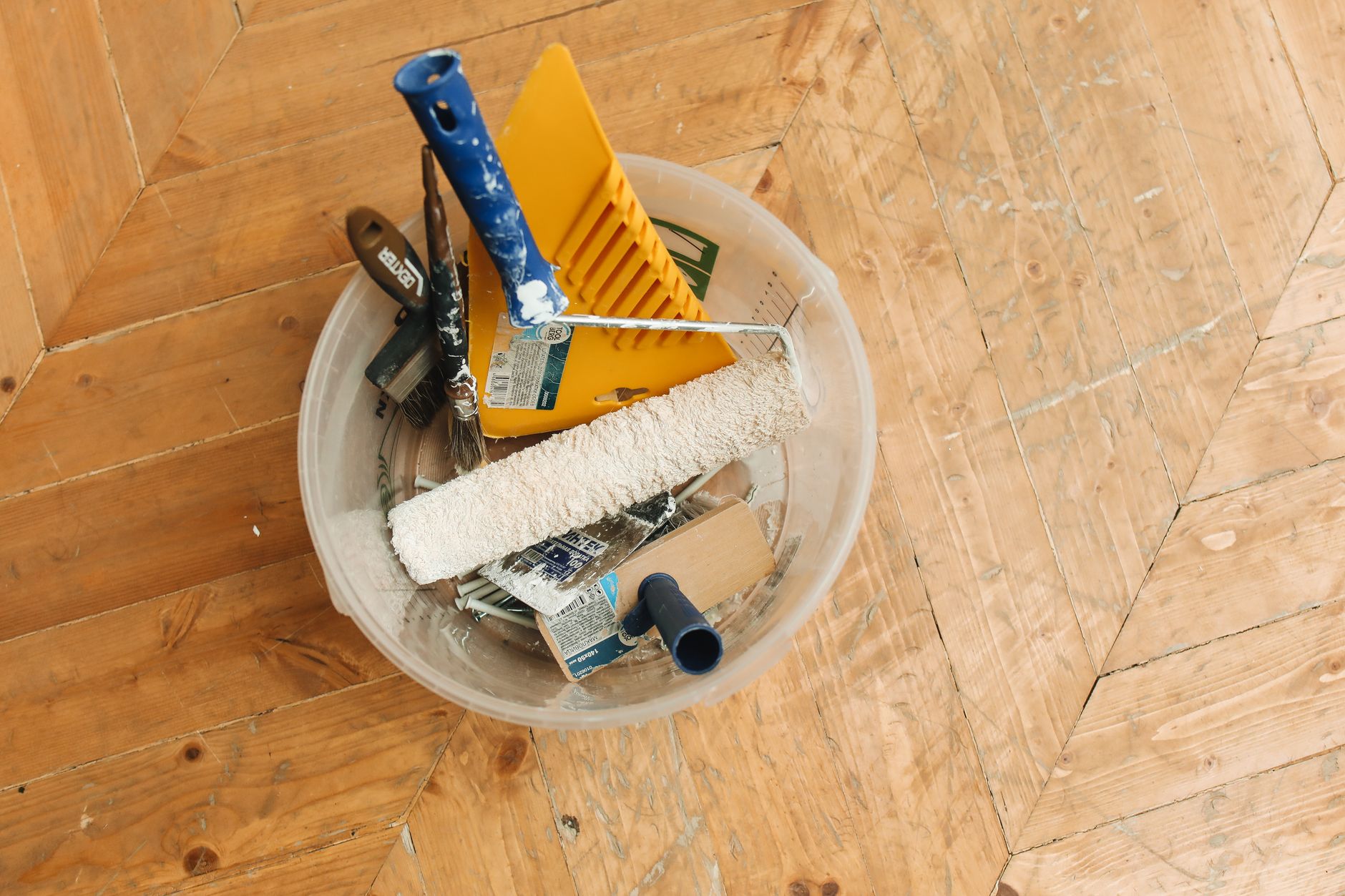A collection of home renovation tools in a bucket on a wooden floor, ready for a painting project. — "Discover the Best Windo