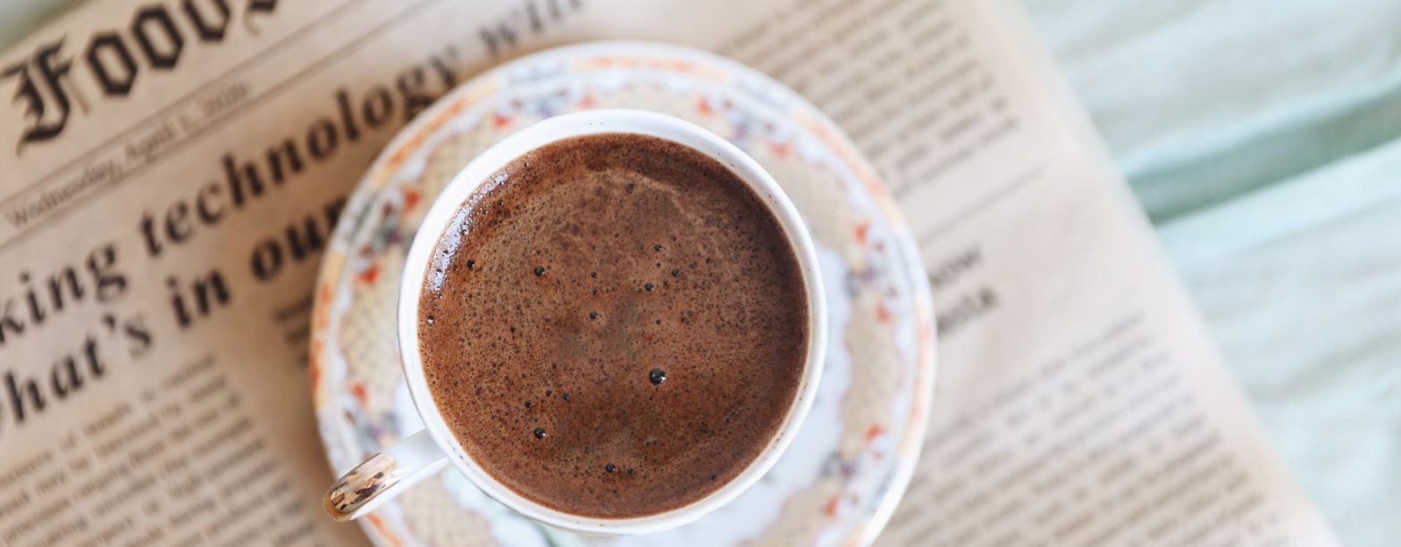 Top view of a black coffee cup on an old newspaper, perfect for a cozy morning. — examplearticle