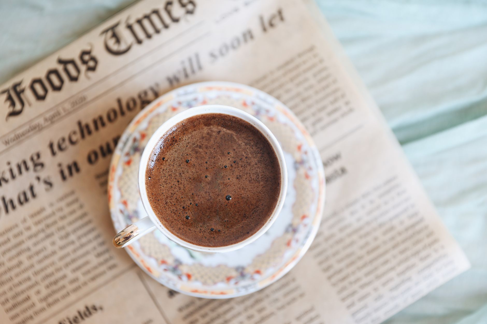Top view of a black coffee cup on an old newspaper, perfect for a cozy morning. — examplearticle