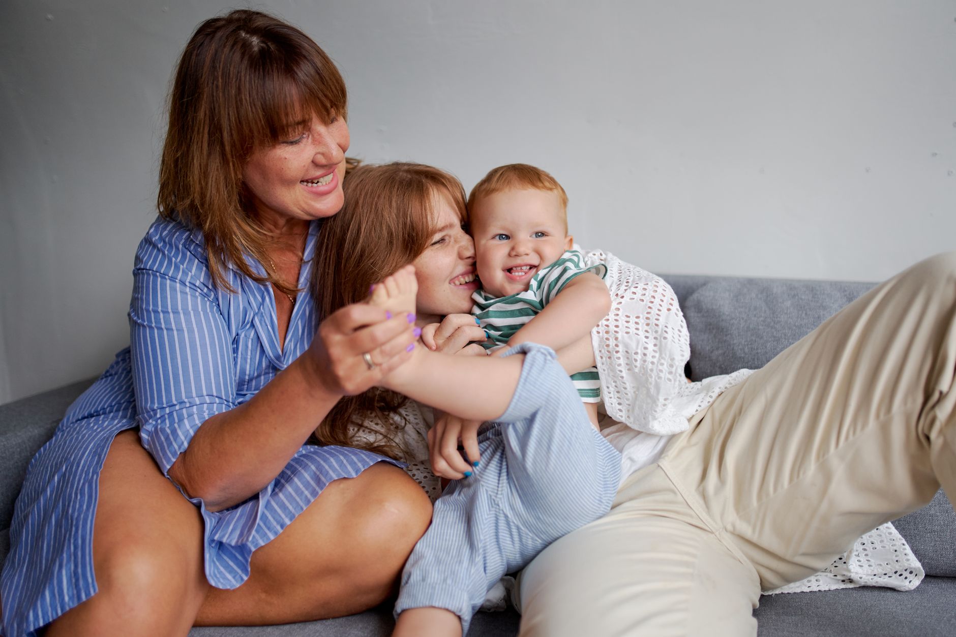 Happy grandmother with daughter and little boy resting on cozy couch in living room — Gorgeous Prostitutes Adler On Sochifeya