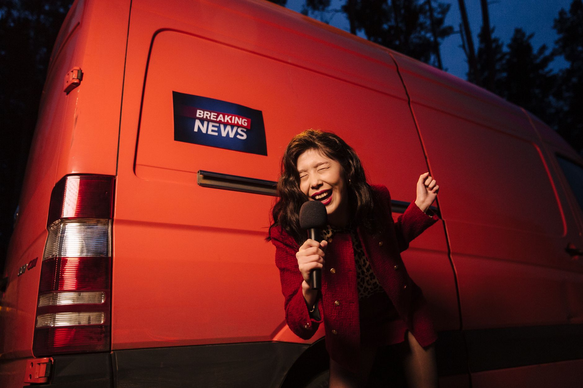 Asian woman reporter energetically broadcasting with a microphone in front of a news van at night. — How a Tobacco Beetle Tra