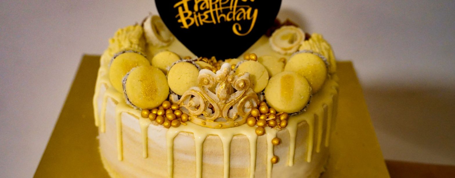 Stylish yellow birthday cake adorned with macarons and golden accents, perfect for celebrations. — How Salami Is Changing the