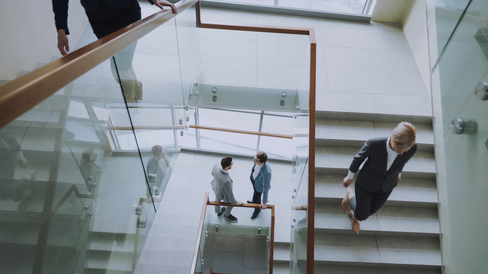 Aerial view of professionals conversing in a glass staircase in a modern office. — Scientific Imaging Evidence for Legal Defe