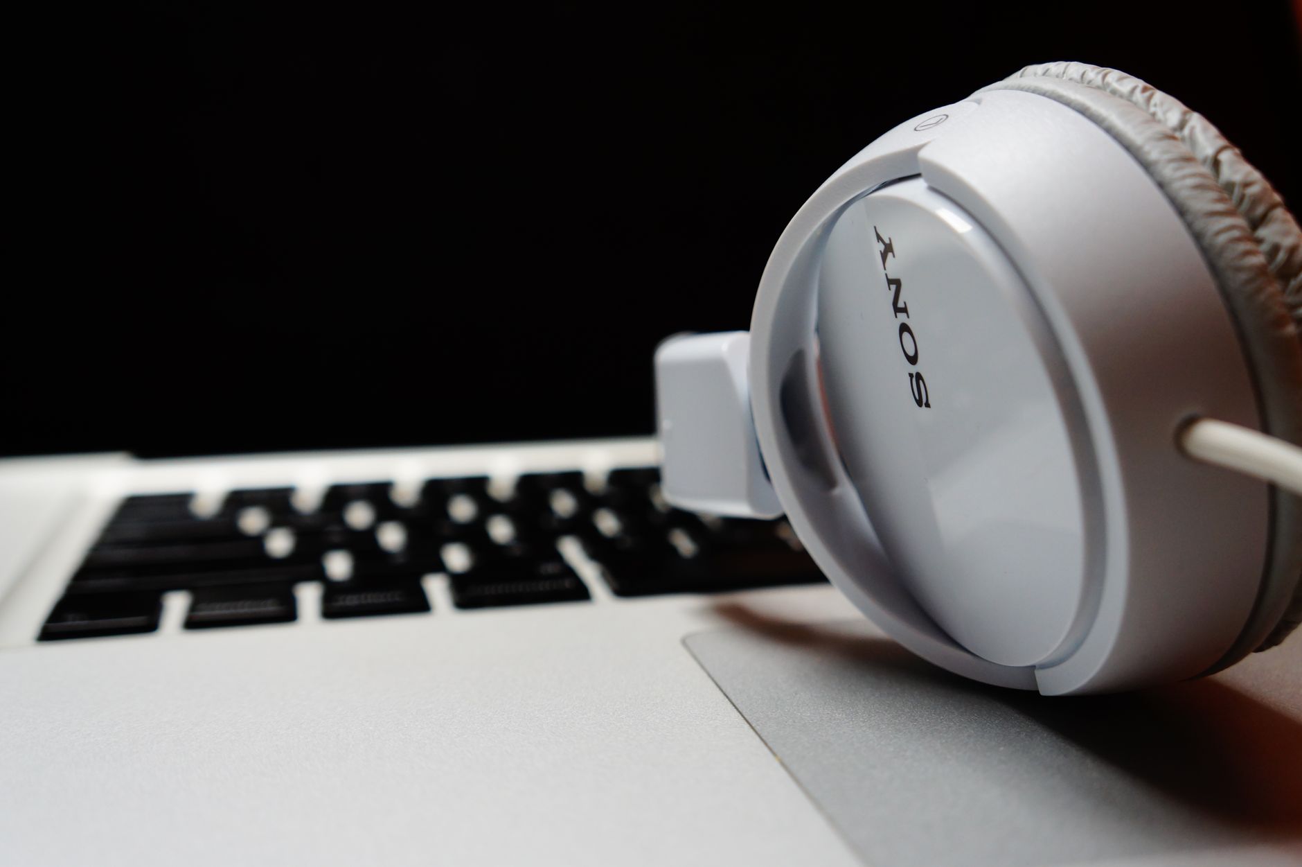 White headphones resting on a laptop keyboard, highlighting modern technology. — The Hidden Cost of Manual Systems: Why Autom