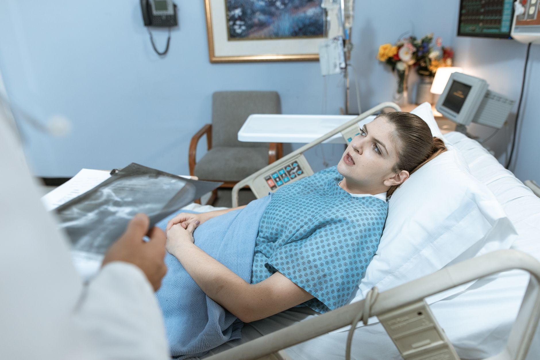 Caucasian woman in hospital bed receiving care from healthcare professional. — The Importance of Ethics in Epidemiology Studi